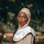 Outdoor portrait of an elegant woman in traditional clothing and hijab, exuding grace.